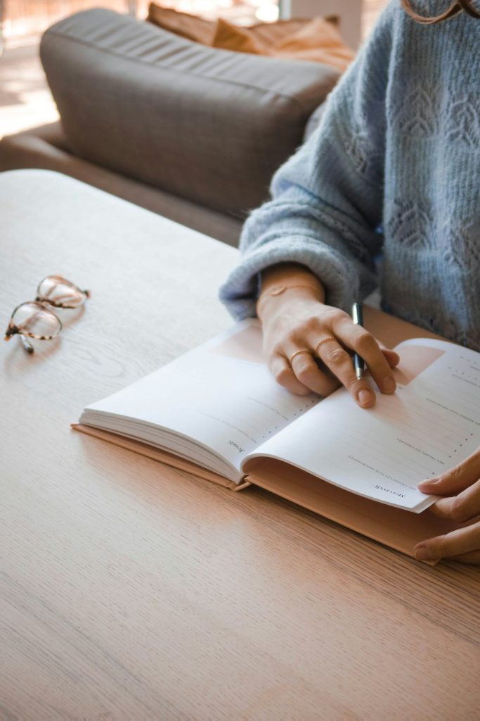person-in-gray-sweater-holding-white-book-rdvz9x0xgfi